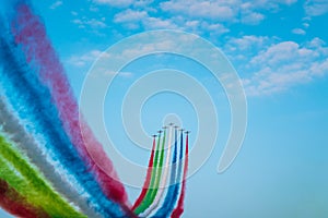 Jet planes leaving colorful trails on the sky during an airshow photo