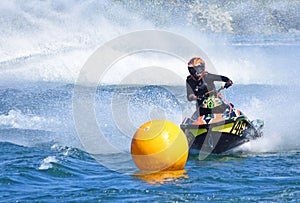 Jet Ski competitor cornering at speed creating at lot of spray.