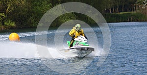 Jet Ski competitor cornering at speed creating at lot of spray.