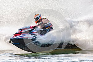 Jet ski racer drives watercraft splashing in sunset while racing at South Russian Aquabike