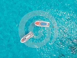 Jet skis for rent are parked in blue lagoon tropical sapphire, aerial top view