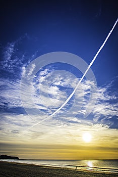 Jet stream across a blue sunrise sky