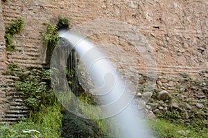 Jet of water coming out of an ancient wall