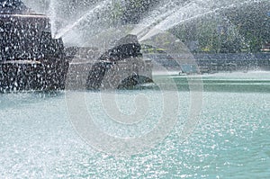 Drops and jets of water from a fountain in a water pool