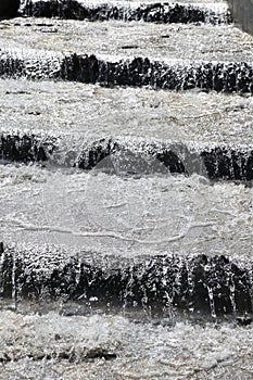 Jets of water running down the steps of the stairs during heavy rain