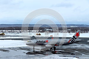 Jetstar plane getting ready for take off at Chitose airport on a snowy day Sapporo