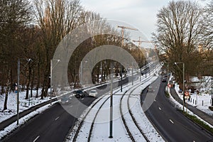 Jette, Brussels, Belgium - Brdige view over lightrail tramway tracks and asphalt roads covered with snow