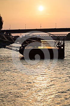 Jetty on Danube river at yellow dawn