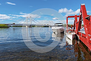 Jetty and motor boats in the border of Stroms vattudal, an extensive water system in Swedish Jamtland. The Stromsund bridge is at