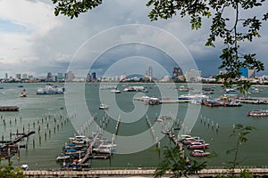 Jetty at Pattaya bay with blue sky and gray clouds covered