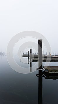 Jetty post and boating docks on a misty morning