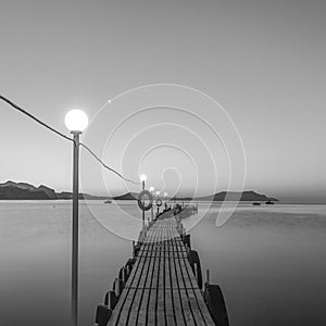 Jetty on sea at dawn. Black and white