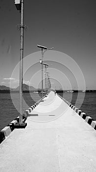 Jetty on sea, striped black and white hard shoulder