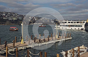 Jetty on the waterfront and floating ship on the Bosphorus on a sunny day in Istanbul, Turkey. Toned image.