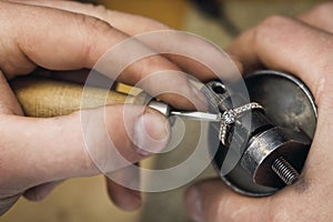 Jeweler adjusts precious stones in a gold ring