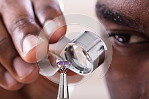 Jeweler Examining Diamond Through Loupe