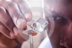 Jeweler Examining Diamond Through Loupe