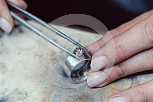 Jeweler setting a precious stone with pincers on a ring