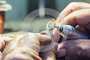 Jeweler weler using a copper wire brush with a flex shaft.