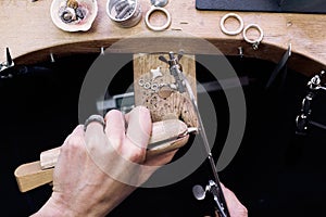 Jeweler at work in jewelery workshop, woman hands making silver thing. tools set.