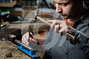 Jeweler working with the hammer