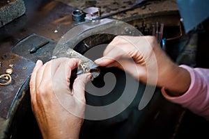 Jeweler working with needle file gold ring in jewellery worksho