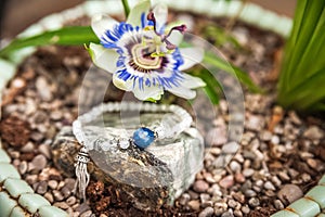 Jewelery made of natural stones against the backdrop of blossoming pasiflora. Bracelets, rings, necklaces, handmade earrings close