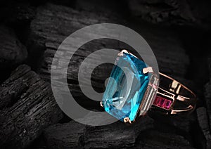 Jewelery ring with aquamarine gemstone on dark coal background,