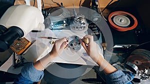 Jeweller uses jeweler`s loupe while working with a big ring.