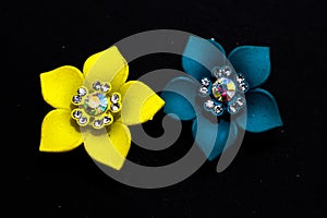 Jewellery artifact yellow,blue flowers design earrings on black shadow background.