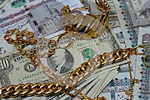 Jewellery or jewelry with USD American dollars and EGP LE Egyptian pounds cash money banknotes, brooches, rings, necklaces,