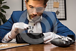 Jewelry appraiser holding magnifying glass while