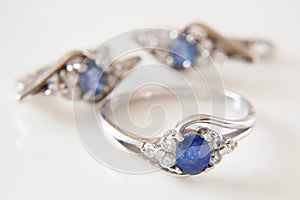 Jewelry. beautiful silver earrings pair and ring set with blue sapphire stones on white background