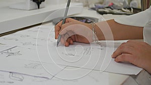 Jewelry designer s hand sketching out designs in studio photo