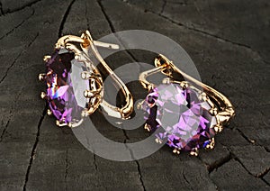 Jewelry Earrings with gems on black wood background