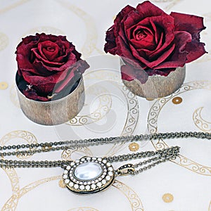 Jewelry and flowers. Necklace and red roses