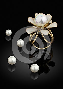 jewelry golden ring with pearl on black background with reflection