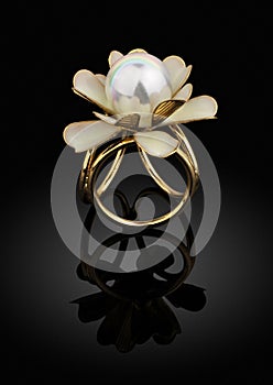 jewelry golden ring with pearl on black background with reflection