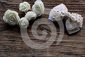 Jewelry and hair accessories. Elegant bow with holographic stones and rhinestones with a pink tint. There are cute milky roses aro