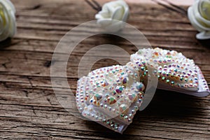 Jewelry and hair accessories. Elegant bow with holographic stones and rhinestones with a pink tint. There are cute milky roses aro