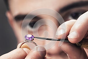 Jewelry master examines the gold ring for defects