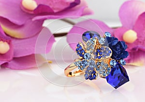 Jewelry ring with blue gems and flower background