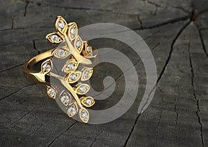 Jewelry ring with diamonds on dark wood background, copy-space