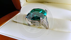 Jewelry ring with enormous green emerald gemstone. Cut finished gem stones.