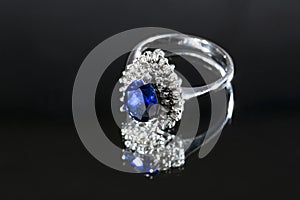 jewelry ring witht big blue sapphir on black coal background photo