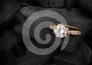 jewelry ring witht big diamond on dark coal background, soft focus