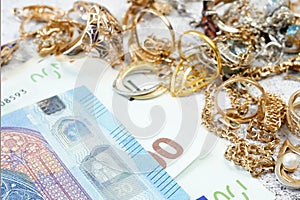 jewelry scrap of gold and silver and money, pawnshop concept jeweler looking at jewelry through magnifying glass, jewerly