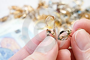 jewelry scrap of gold and silver and money, pawnshop concept jeweler looking at jewelry through magnifying glass, jewerly