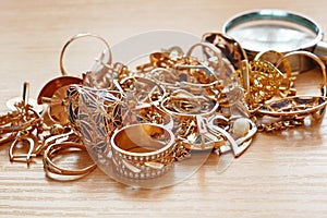 Jewelry scrap of gold and silver and money, pawnshop concept jeweler looking at jewelry through magnifying glass, jewerly inspect