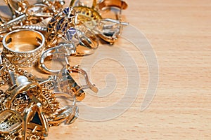 Jewelry scrap of gold and silver on wooden background with copy space, pawnshop concept